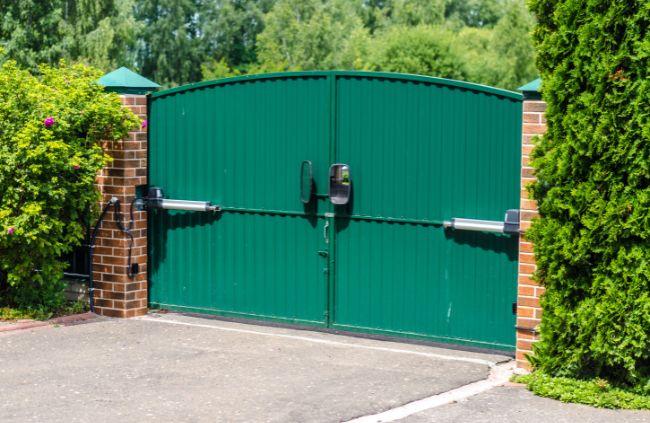 Motorised swing gate system installed by Auto Gate Guys Melbourne, featuring green double gates and brick pillars for a secure driveway entrance Motorised swing gate system installed by Auto Gate Guys Melbourne, featuring green double gates and brick pillars for a secure driveway entrance
